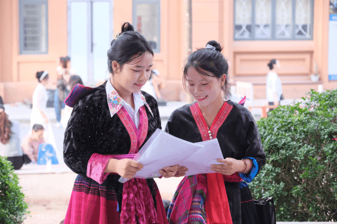 Hai thí sinh đang xem kết quả thi năng khiếu hoặc thông tin tuyển sinh đại học.