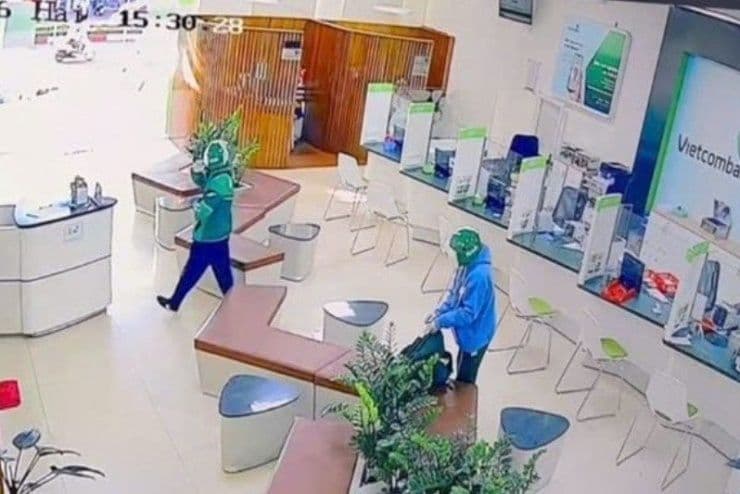 Hai tên cướp mặc áo khoác giống tài xế Grab đang thực hiện vụ cướp bên trong ngân hàng Vietcombank Gia Lai.
