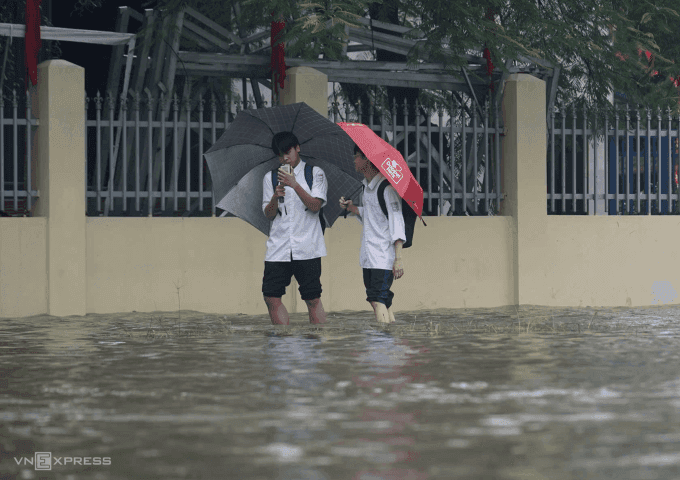 Học sinh Hà Nội lội nước ngập trên đường đi học về trong mùa mưa bão