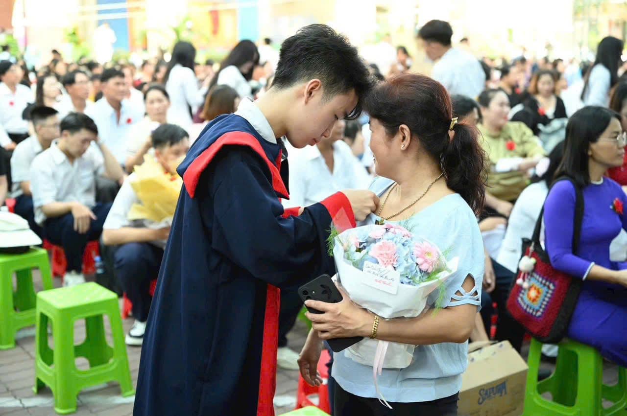 Học sinh tốt nghiệp THPT nhận hoa từ người thân, thể hiện sự hỗ trợ và kỳ vọng