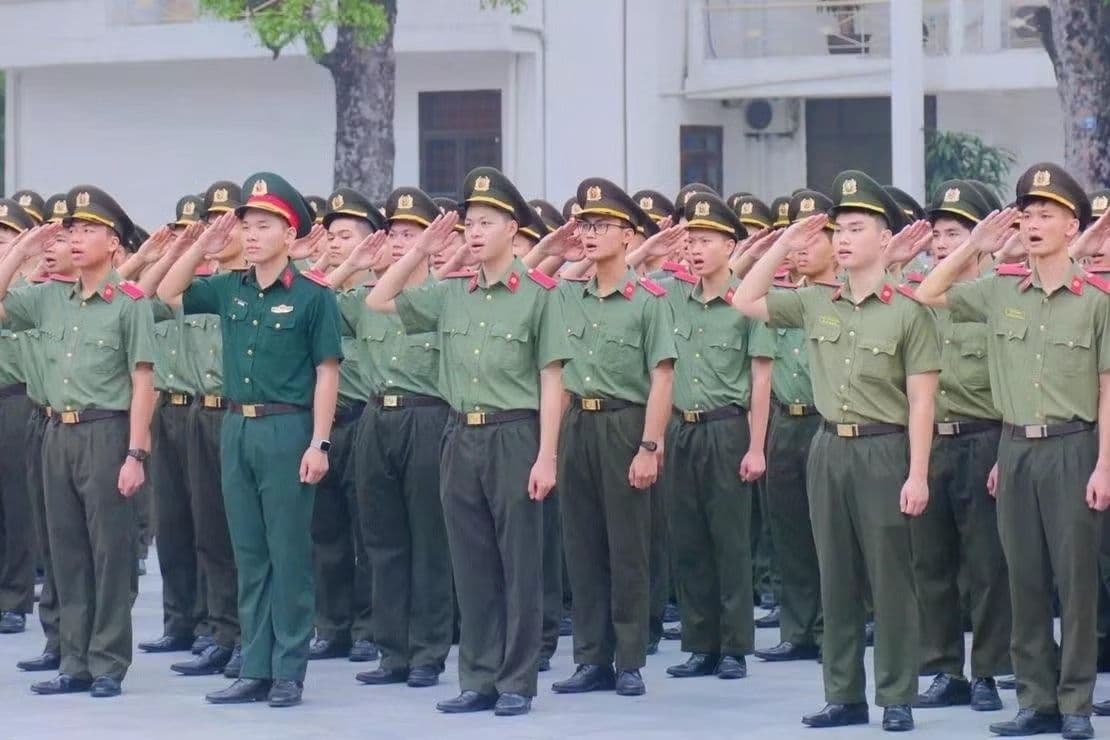 Học viên Học viện An ninh Nhân dân thực hiện nghi thức chào cờ, thể hiện sự kỷ luật và tinh thần phụng sự.