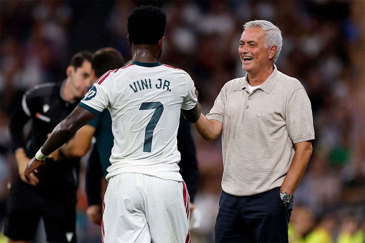 HLV Jose Mourinho cười mãn nguyện trên sân Bernabéu, bắt tay Vinicius Junior.