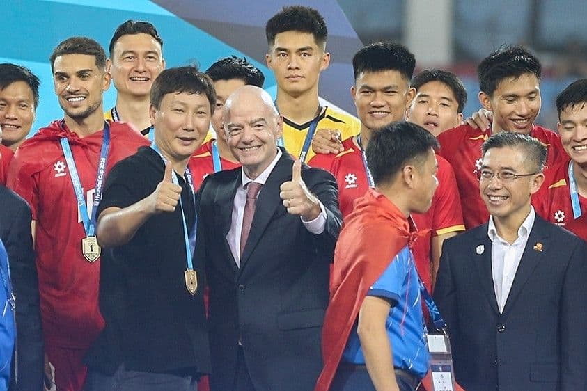 HLV Kim Sang Sik và Chủ tịch FIFA Infantino cùng các cầu thủ Việt Nam, biểu tượng cho sự lãnh đạo và tầm nhìn quốc tế.