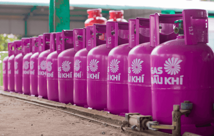 Hàng loạt bình gas màu tím xếp hàng tại một đại lý phân phối, tượng trưng cho thị trường gas biến động và giá cả leo thang.