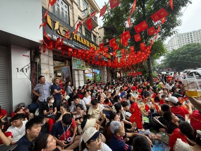 Hàng trăm người dân Hà Nội tập trung trên vỉa hè, mang cờ đỏ sao vàng để theo dõi buổi tổng duyệt diễu binh, thể hiện niềm tự hào dân tộc.
