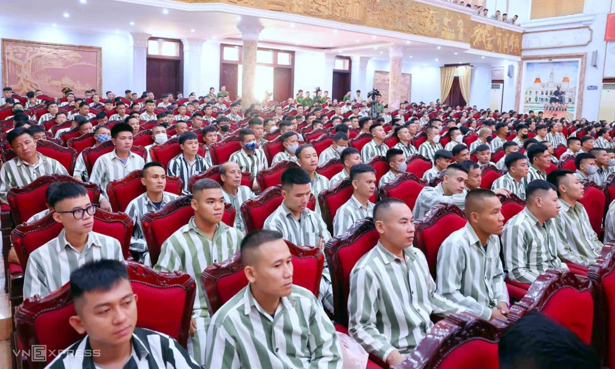Hàng trăm phạm nhân mặc đồng phục sọc ngồi trong hội trường tham dự lễ công bố quyết định đặc xá.