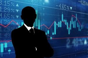 Hình bóng một doanh nhân trước biểu đồ chứng khoán, thể hiện sự phân tích và quyết định đầu tư thông thái.