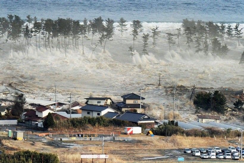 Hình ảnh sóng thần tàn phá bờ biển Nhật Bản, minh họa nguy cơ địa chấn và thảm họa tự nhiên.