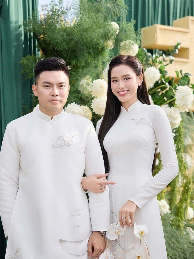 Hoa hậu Đỗ Thị Hà và doanh nhân Nguyễn Viết Vương trong lễ ăn hỏi, diện áo dài trắng thêu họa tiết.