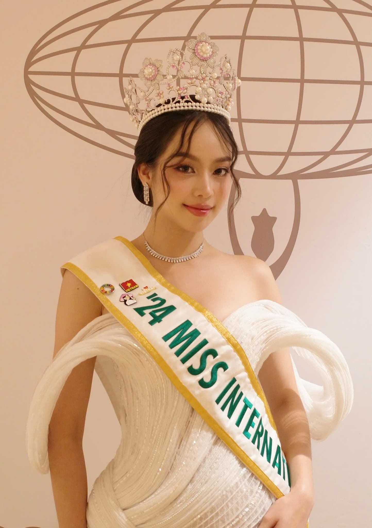 Hoa hậu Thanh Thủy với vương miện Miss International và cờ Liên Hợp Quốc, thể hiện tầm ảnh hưởng và khát vọng toàn cầu.