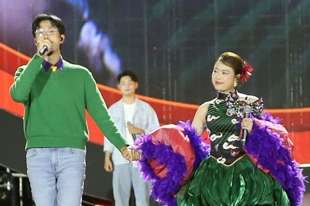 Hoàng Thùy Linh và Đen Vâu biểu diễn trên sân khấu lớn, nắm tay nhau, thể hiện sự hòa điệu giữa truyền thống và hiện đại trong âm nhạc Việt.