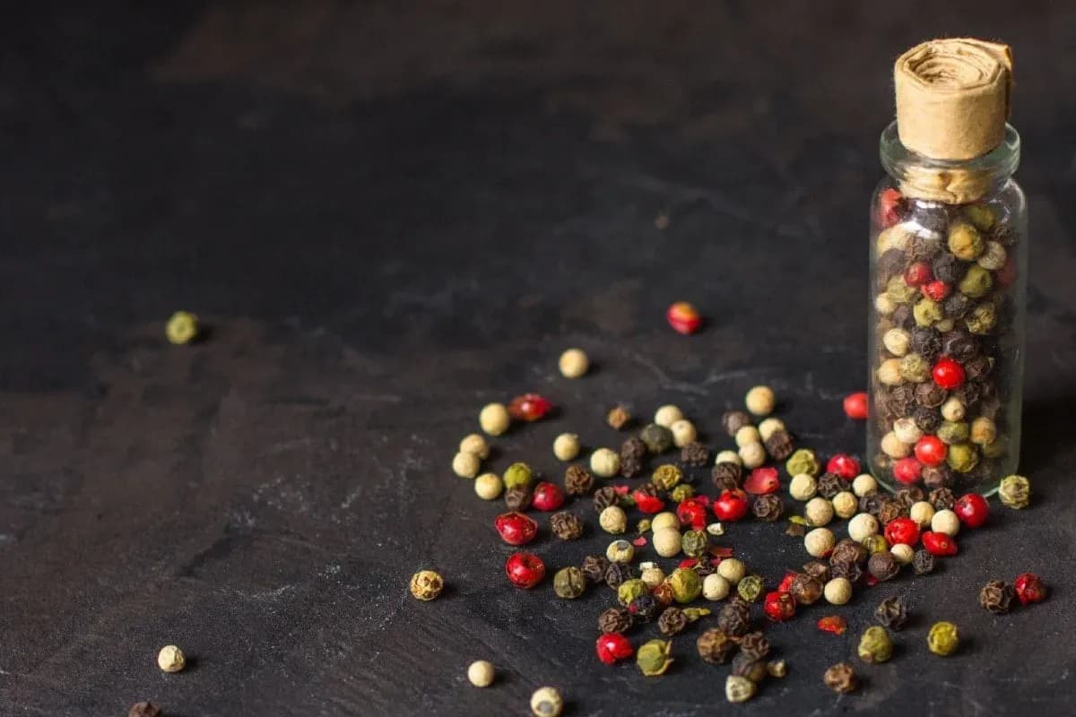 Hạt tiêu các loại (đen, trắng, đỏ, xanh) tượng trưng cho 'vàng đen' và giá trị của hồ tiêu.