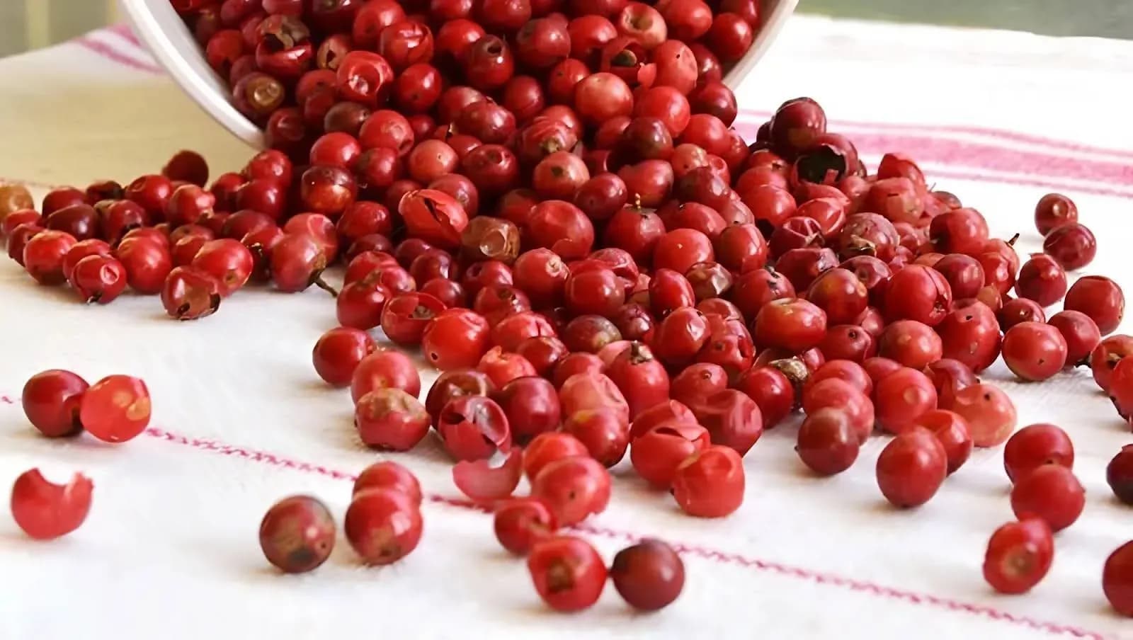 Hạt tiêu đỏ tươi tràn ra từ một chiếc bát, tượng trưng cho sự biến động giá hồ tiêu.