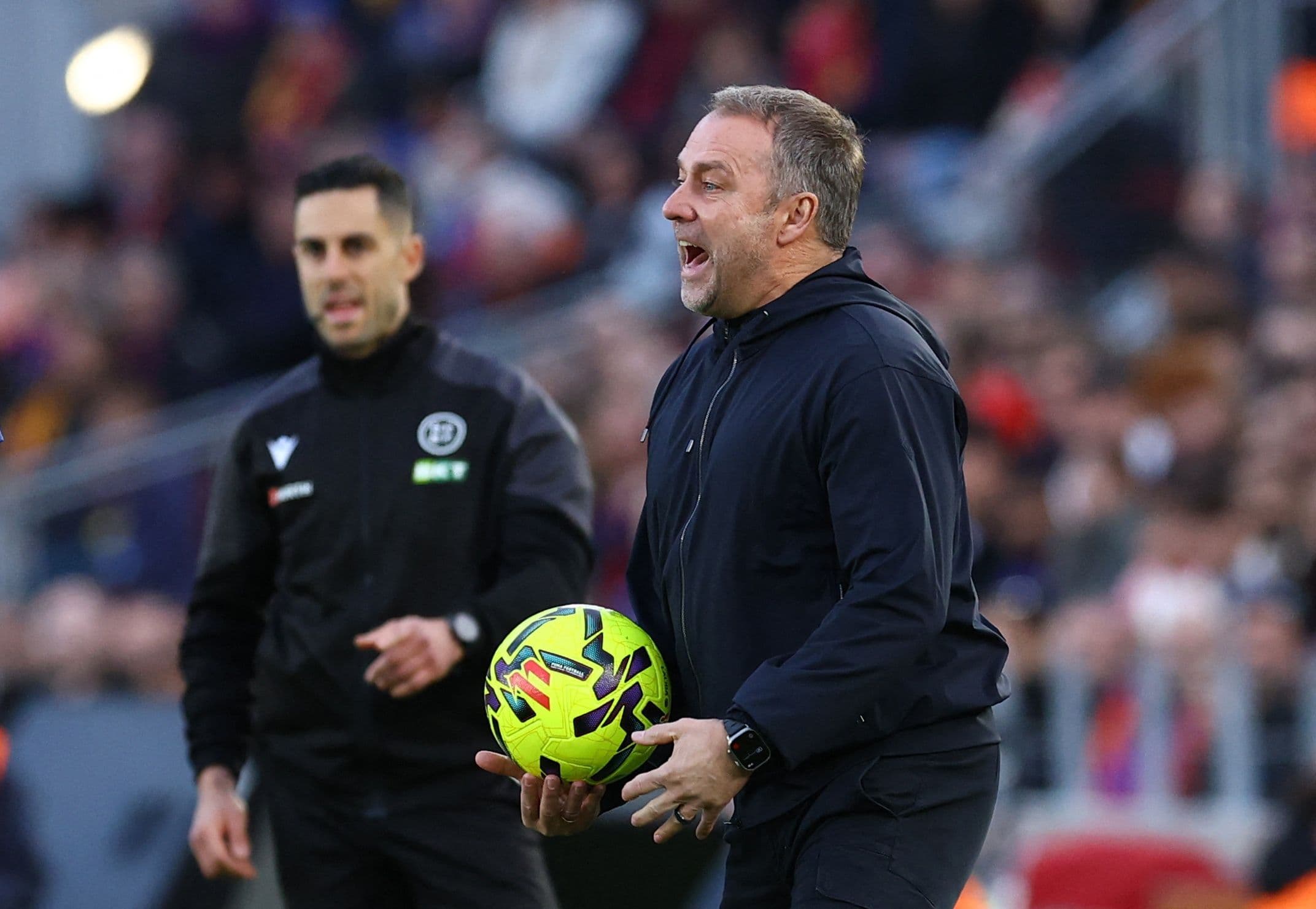 Huấn luyện viên Hansi Flick của Barcelona trên sân, đối mặt với những câu hỏi lớn về tương lai và chiến thuật của đội sau trận thua thảm hại.