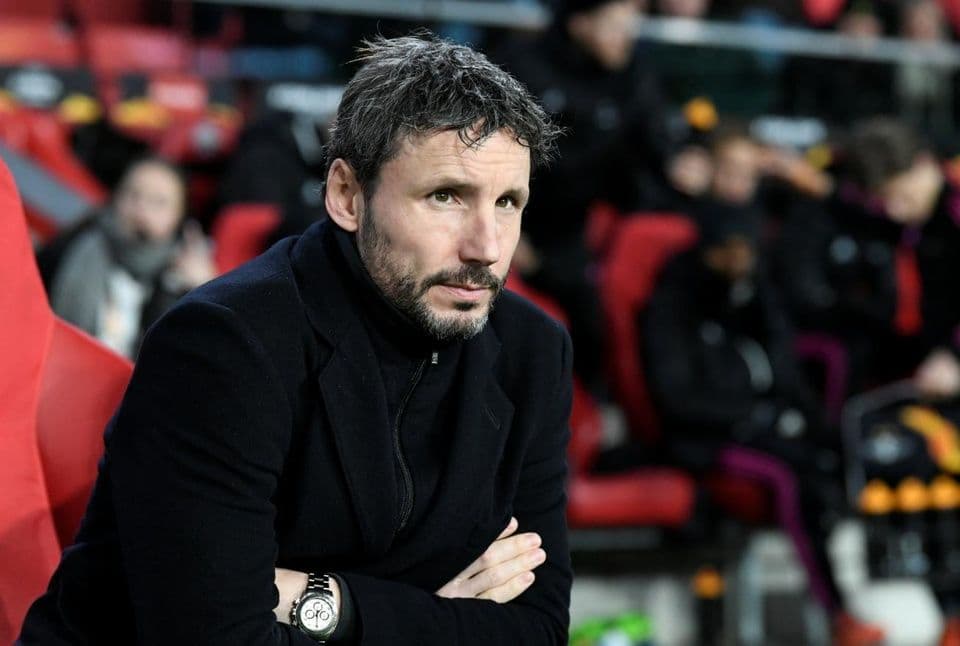 Huấn luyện viên Mark van Bommel trên băng ghế dự bị, thể hiện sự tập trung và vai trò chiến thuật gia.