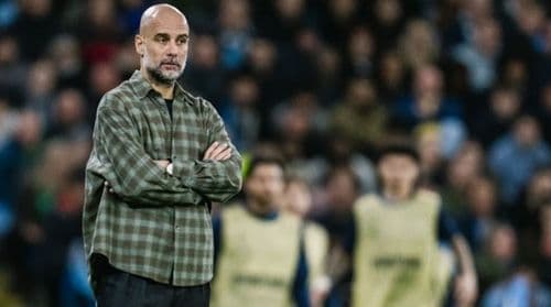 Huấn luyện viên Pep Guardiola đứng trên sân với vẻ mặt trầm tư, thể hiện tư duy chiến thuật sâu sắc.