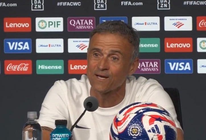 Huấn luyện viên tại buổi họp báo với quả bóng có biểu tượng đội tuyển Hoa Kỳ.