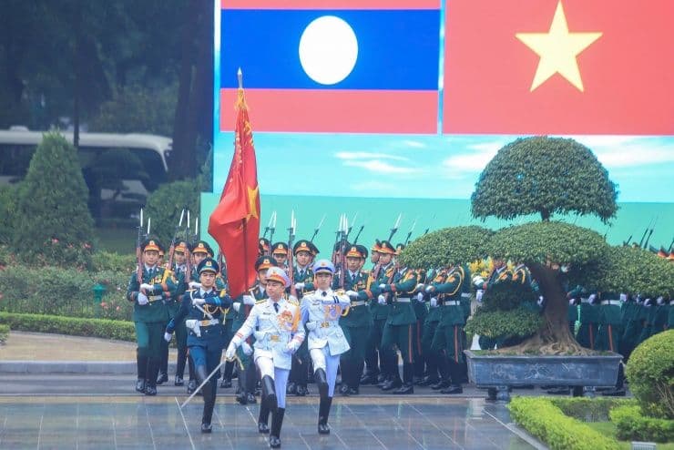 Đội Danh dự Quân đội nhân dân Việt Nam diễu binh chào mừng, tượng trưng cho sức mạnh và sự đoàn kết Việt-Lào trong bối cảnh khu vực.