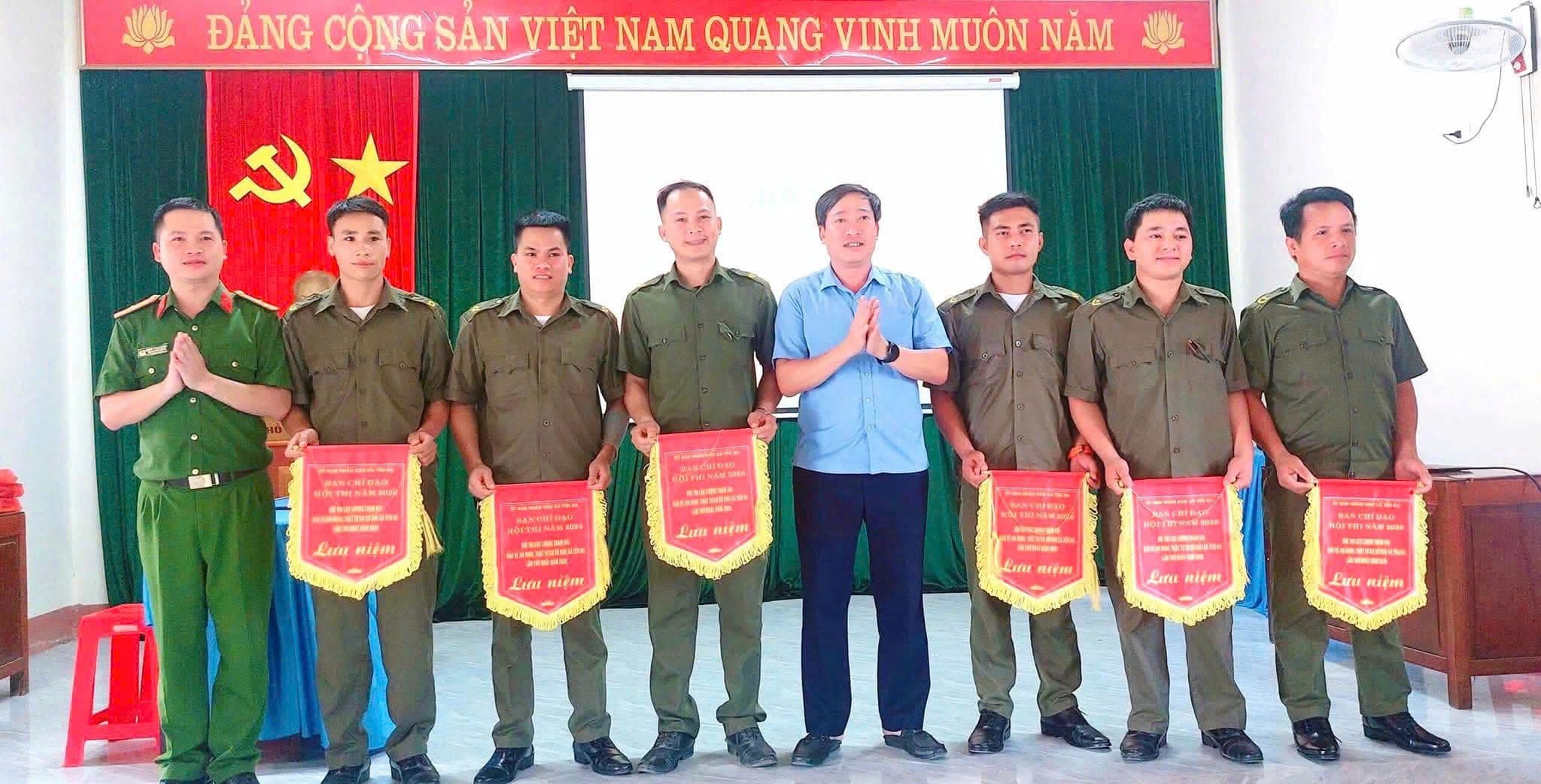 Đại diện các đội thi an ninh trật tự cơ sở nhận cờ lưu niệm, minh họa hoạt động gắn kết cộng đồng và xây dựng niềm tin trong công tác an ninh.