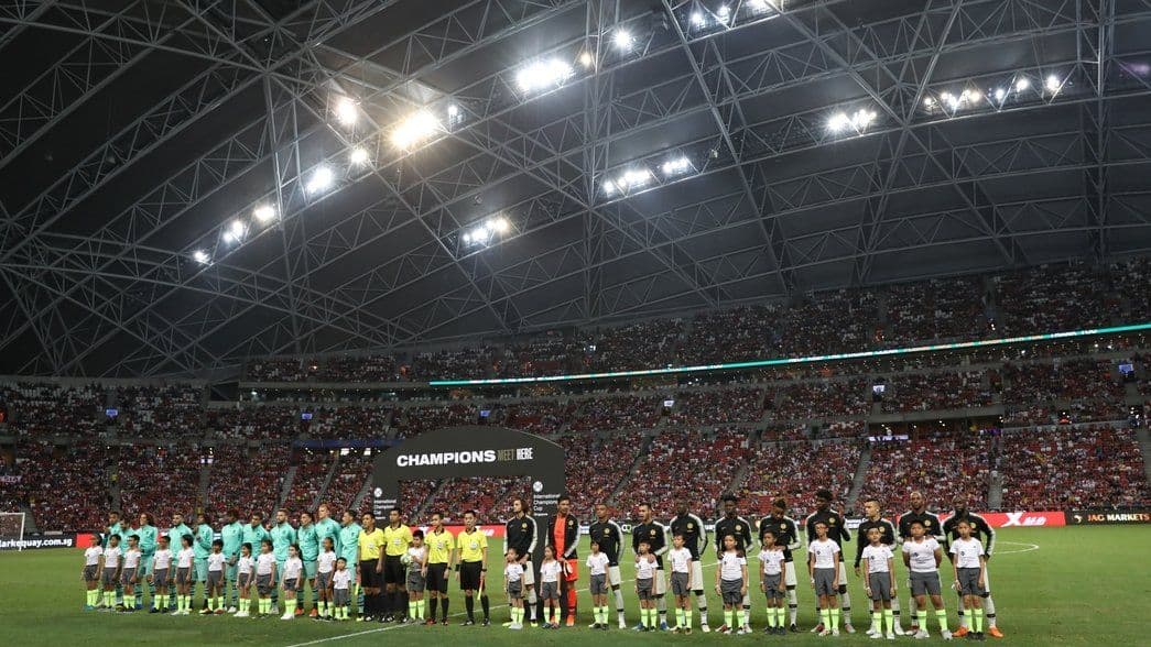 Đội hình Arsenal và các cầu thủ trẻ xếp hàng trên sân vận động Quốc gia Singapore.