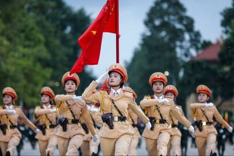 Đội hình nữ quân nhân diễu binh với cờ đỏ, thể hiện hào khí và niềm tự hào dân tộc trong dịp Quốc khánh.