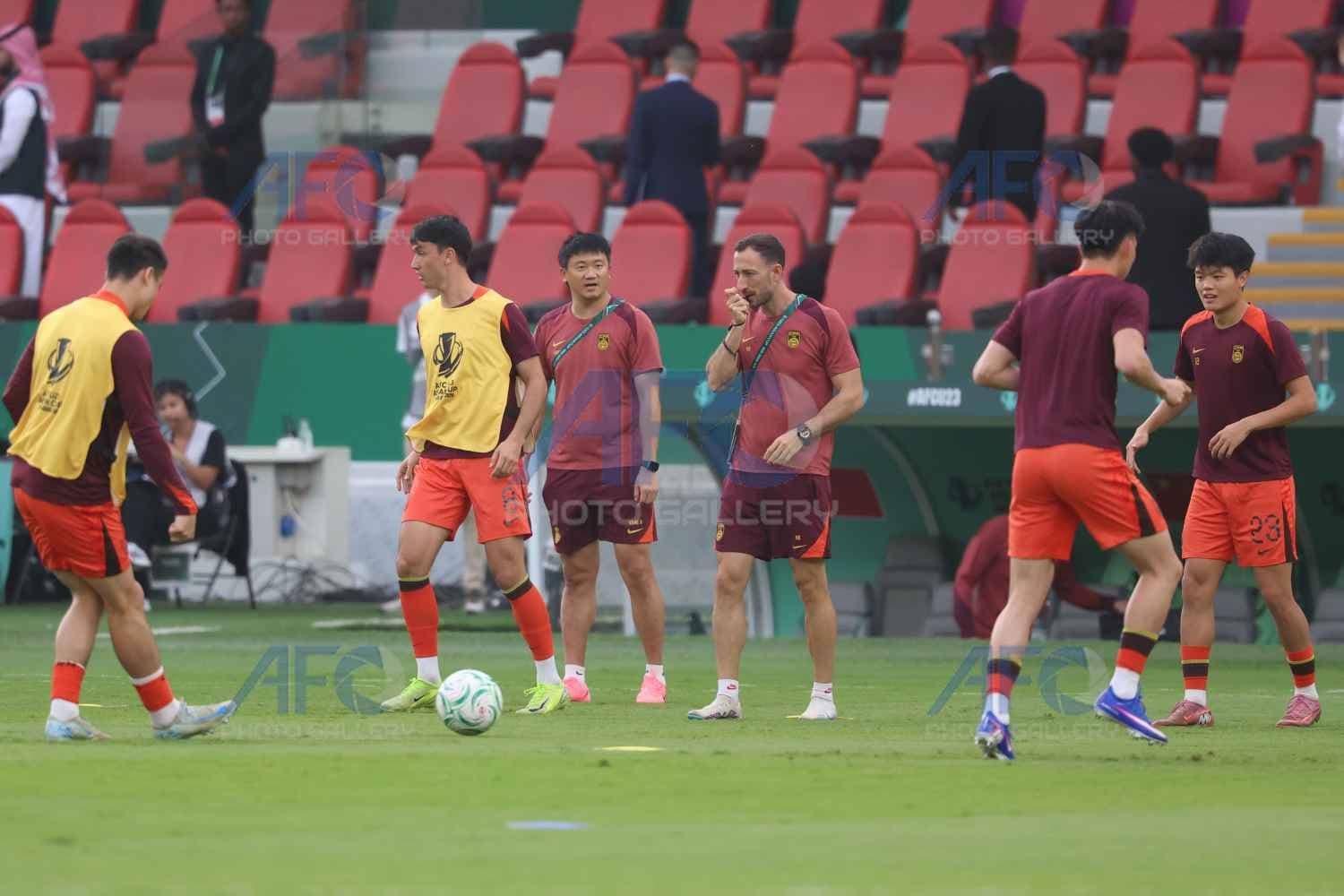 Đội hình U23 Trung Quốc và huấn luyện viên Antonio Puche trên sân tập, chuẩn bị cho trận đấu.