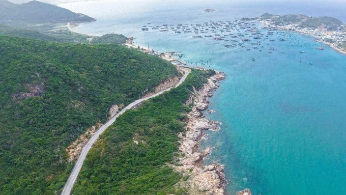 Đại lộ biển ven bờ biển xanh ngắt với núi non và làng chài, biểu tượng cho dự án kết nối sân bay Cam Ranh và phát triển kinh tế biển.