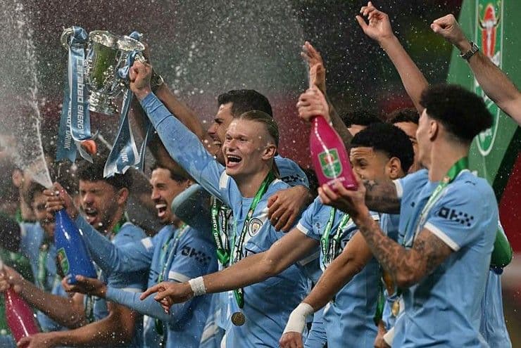 Đội Manchester City ăn mừng chức vô địch League Cup, với Erling Haaland nâng cao cúp giữa pháo hoa và đồng đội.