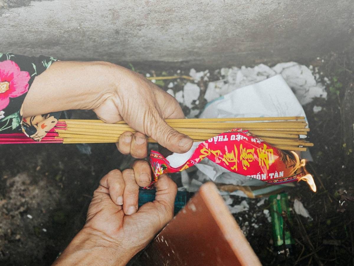 Đôi tay thắp nén hương tưởng nhớ người đã khuất trong tiết Thanh Minh.