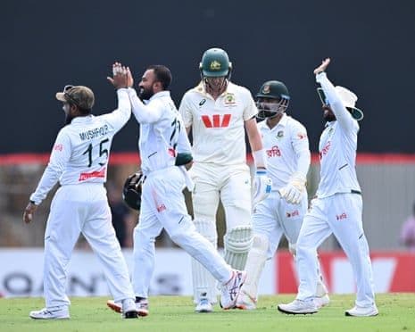 Đội trưởng Australia Pat Cummins rời sân sau khi bị Mehidy Hasan loại, trong khi các cầu thủ Bangladesh ăn mừng chiến thắng lịch sử.