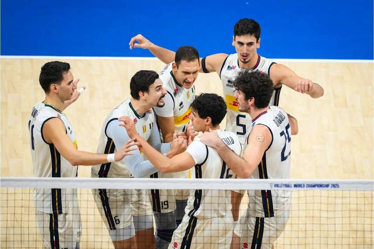 Đội tuyển bóng chuyền Ý ăn mừng hoặc hội ý trên sân, thể hiện cảm xúc thăng hoa và tinh thần đồng đội.