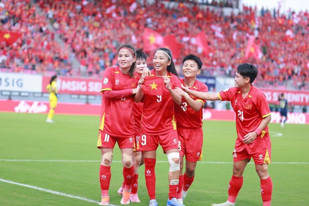 Đội tuyển bóng đá nữ Việt Nam ăn mừng chiến thắng với lá cờ Tổ quốc.