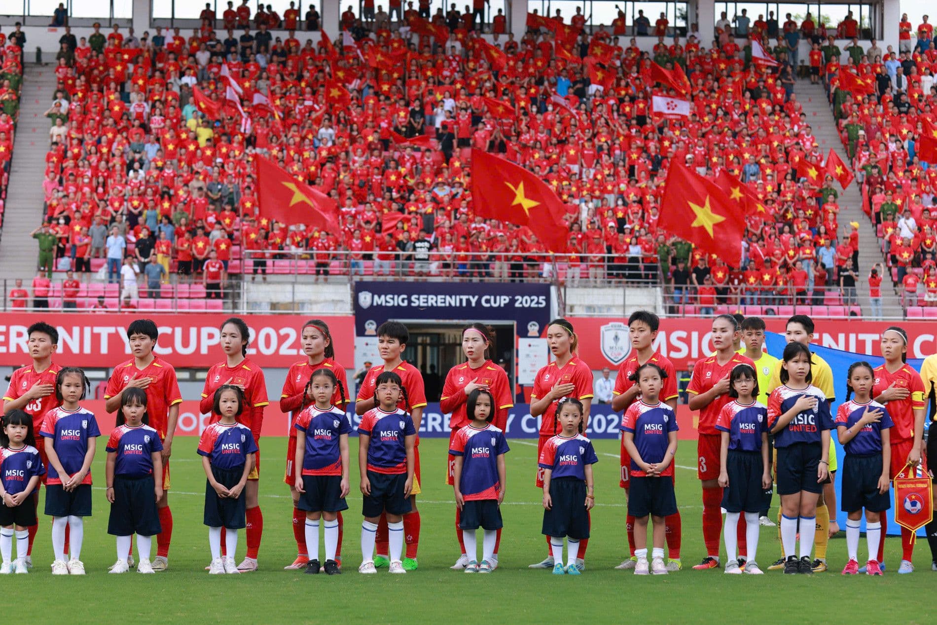 Đội tuyển nữ Việt Nam cùng các em nhỏ trong lễ chào cờ, thể hiện tinh thần tương lai bóng đá.