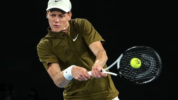 Jannik Sinner đang thực hiện cú đánh mạnh mẽ trong trận đấu quần vợt.