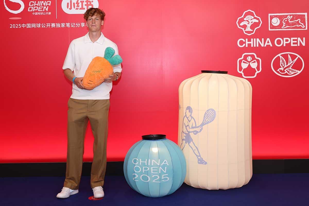 Jannik Sinner tại sự kiện quảng bá China Open 2025 ở Bắc Kinh, cầm một củ cà rốt nhồi bông.
