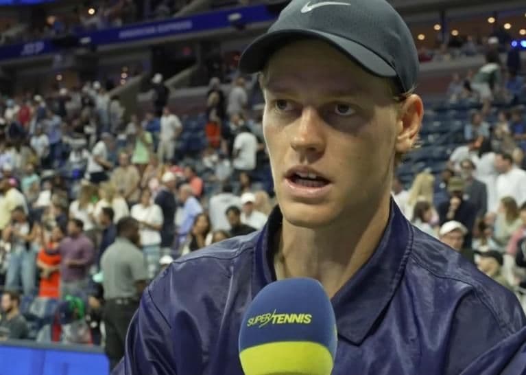 Jannik Sinner trả lời phỏng vấn trên sân đấu, chia sẻ về chiến thuật và sự tự tin tại Grand Slam.