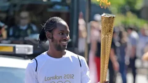 Jason Arday rạng rỡ khi mang ngọn đuốc Olympic, biểu tượng cho hành trình phi thường và thành công của anh.