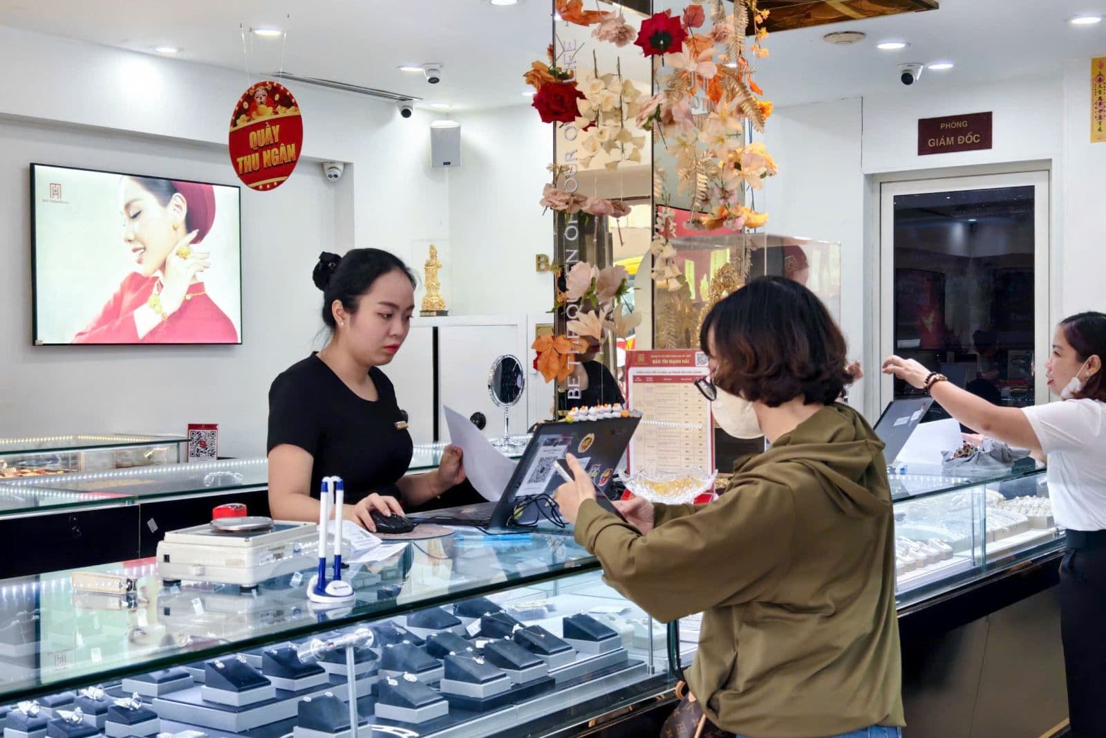 Khách hàng giao dịch tại cửa hàng vàng, phản ánh hoạt động thị trường và sự chênh lệch giá vàng SJC so với thế giới.