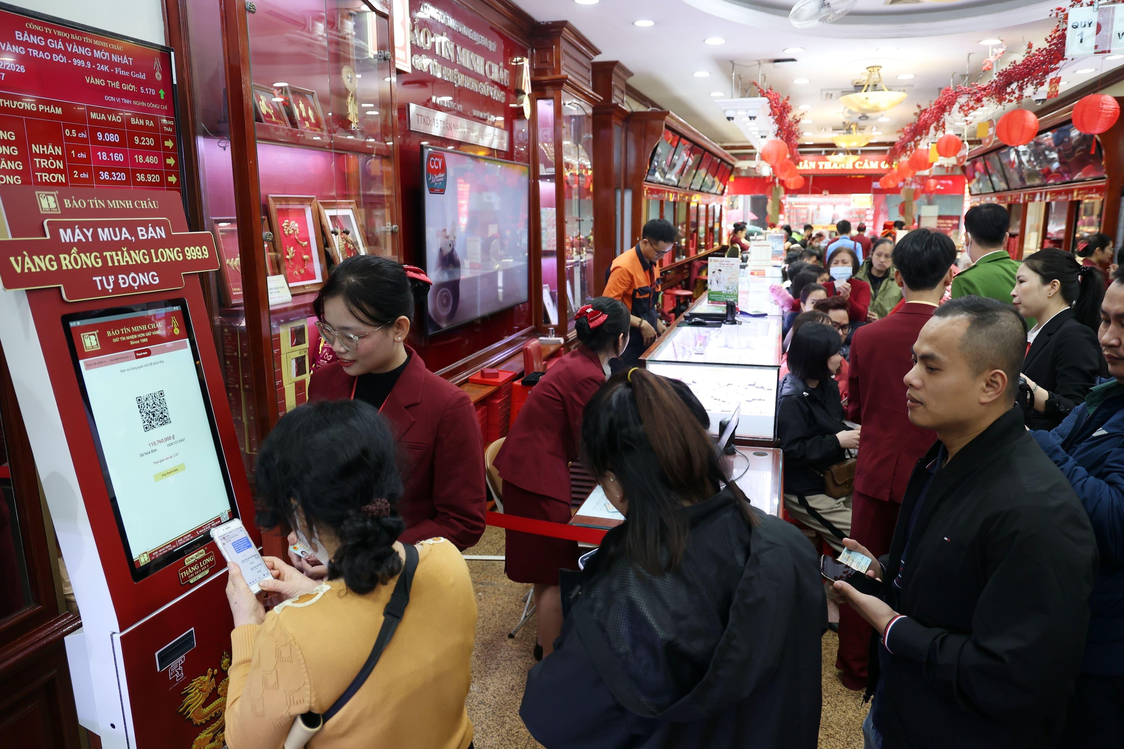 Khách hàng giao dịch tại quầy và máy tự động trong tiệm vàng, phản ánh hoạt động mua bán vàng sôi động và các quy định mới.