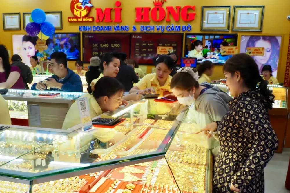 Khách hàng giao dịch vàng miếng SJC và vàng nhẫn tại cửa hàng vàng ở Việt Nam, phản ánh biến động thị trường.