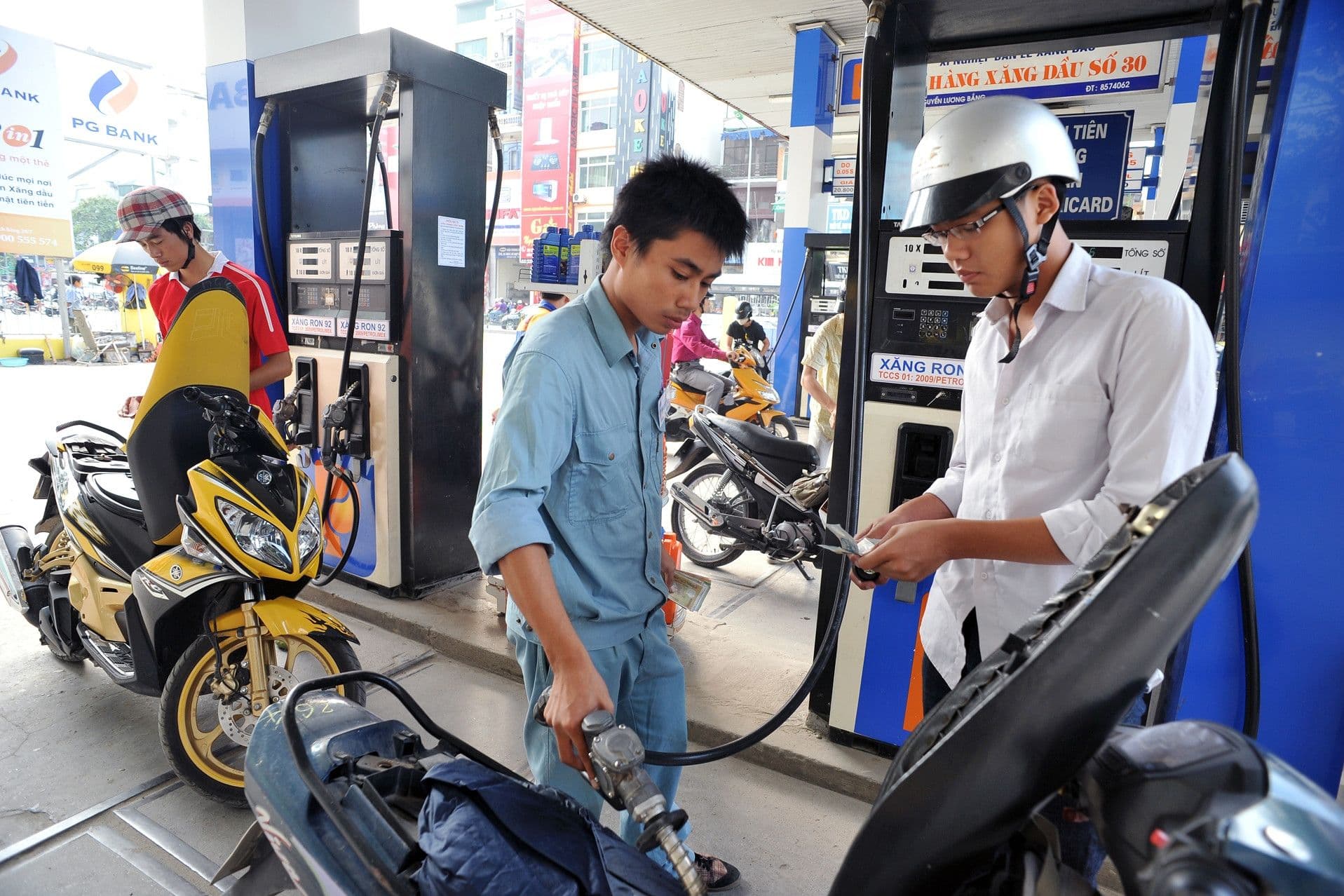Khách hàng thanh toán tiền xăng tại cây xăng, thể hiện sự tương tác giữa thị trường và chính sách điều hành giá
