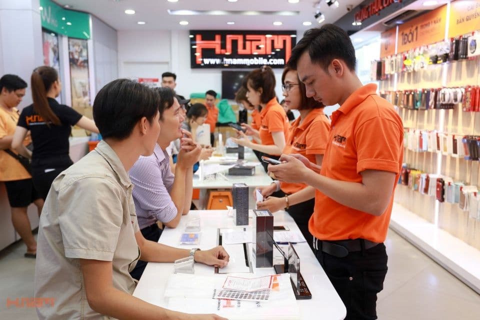 Khách hàng và nhân viên tại một cửa hàng HnamMobile trong thời kỳ phát triển