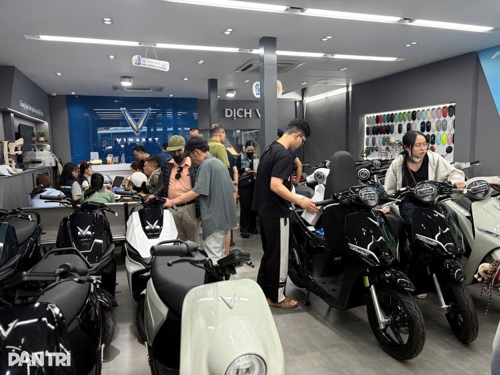 Khách hàng xem và mua xe máy điện VinFast tại cửa hàng, thể hiện sự phát triển của thị trường xe điện Việt Nam
