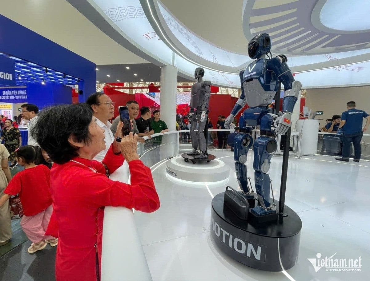 Khách tham quan, bao gồm cả người lớn tuổi, hào hứng chụp ảnh robot công nghệ cao, tượng trưng cho sự kết nối giữa quá khứ và tương lai, khát vọng vươn tầm của Việt Nam.