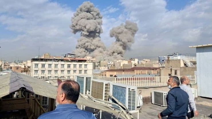 Khói bốc lên từ các tòa nhà, minh họa xung đột địa chính trị tại Trung Đông ảnh hưởng đến giá vàng.