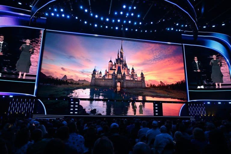 Khán giả tại sự kiện D23 2026 theo dõi màn hình lớn chiếu lâu đài Disney huyền ảo lúc hoàng hôn, tượng trưng cho phép màu và tương lai của Disney.