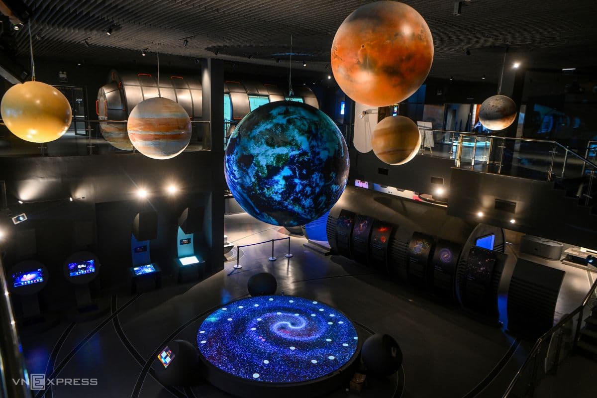 Không gian trưng bày chính tại Bảo tàng Vũ trụ Việt Nam với các mô hình hành tinh treo lơ lửng và màn hình tương tác dưới sàn