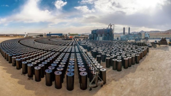Kho chứa hàng trăm thùng dầu, tượng trưng cho quy mô nhiên liệu hóa thạch và thách thức chuyển đổi sang năng lượng xanh.