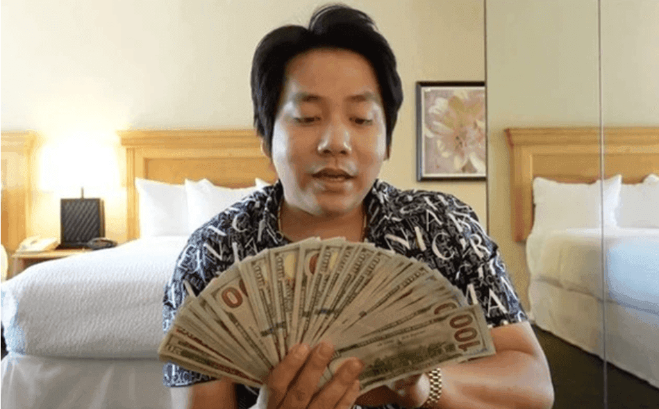 Khoa Pug cầm xấp tiền đô la, thể hiện sự giàu có và hào quang triệu đô