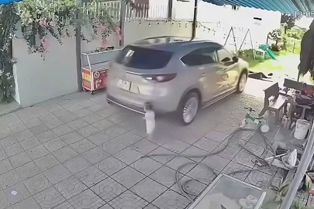 Khoảnh khắc ô tô lùi cán bé gái trong sân nhà, minh họa điểm mù và sự chủ quan trong 'vùng an toàn ảo'.